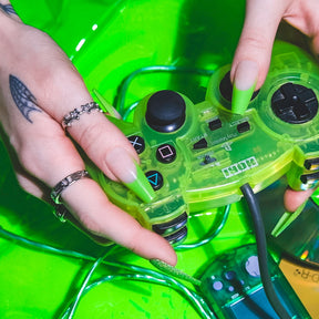 Two hands holding lime green translucent Nintendo Playstation controller while wearing Lime green french tips with full glitter accent nails.