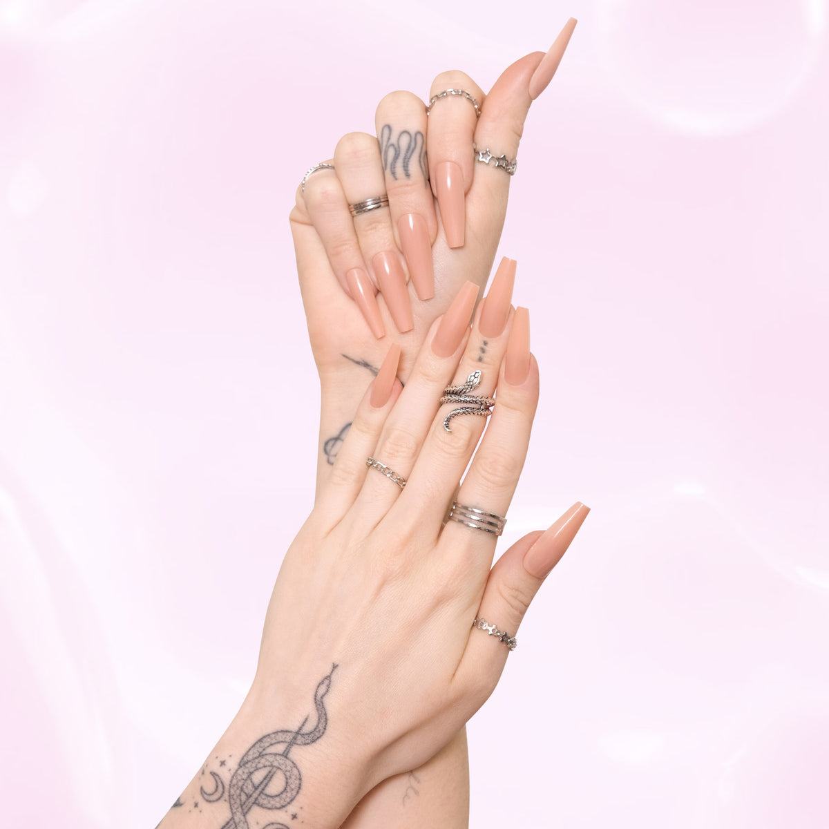Two hands wearing universally flattering acrylic nude press-on nails.
