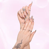 Two hands wearing our exclusive mixed animal print french tip design.